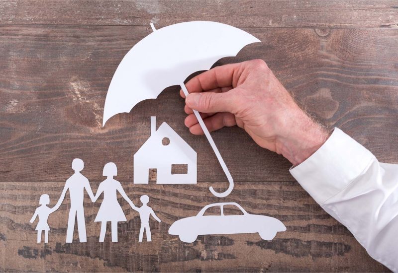 Insurer protecting a family, a house and a car with his hands holding umbrella ; multiple exposure